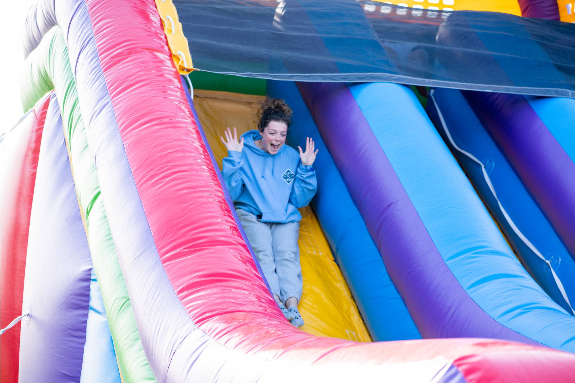 Student sliding down inflatable slide at Lakerpalooza